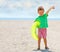 Happy kid with rubber ring on the beach