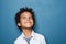 Happy kid school boy portrait. Little child boy looking up on blue background