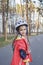 Happy kid in sport helmet riding on roller skates at park, spring family activity, outdoors