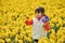 Happy kid with spring flowers on yellow daffodils field, little girl on vacation in Netherlands