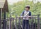 Happy kid standing on bridge on tree house in playground Active child wearing jumper playing outdoor in forest park, Portrair