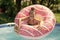 Happy kid swim in donut pool float in swimming pool on sunny summer day, floatation