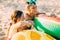 Happy kids boy and girl with an inflatable swimming circle, play and have fun sitting on the sand on the beach