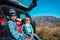 Happy kids-boy and girls- enjoy travel by car in moutains, family vacation