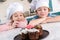 happy kids in chef hats looking at delicious cupcakes