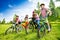 Happy kids in colorful bike helmets holding bikes