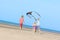 Happy kids flying kite on the beach