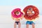 Happy kids in glasses and swimming trunks with donut rubber rings ready for summer vacation