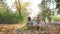 Happy kids have fun on nature in backlight, throw yellow leaves into air in autumn park