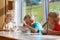 Happy kids having healthy breakfast in the kitchen