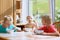 Happy kids having healthy breakfast in the kitchen