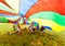 Happy kids hiding under colorful parachute