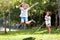 Happy kids play outdoor. Children skipping rope