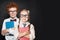 Happy kids pupils in glasses holding books on chalkboard background