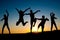 Happy kids silhouettes jumping on the beach