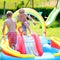 Happy kids splashing in inflatable garden pool