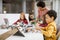 Happy kids with their African American female science teacher with laptop programming electric toys and robots at robotics