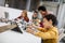 Happy kids with their African American female science teacher with laptop programming electric toys and robots at robotics