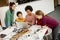 Happy kids with their African American female science teacher with laptop programming electric toys and robots at robotics