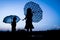 Happy Kids with an umbrella silhouette on nature in the park sunset