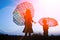 Happy Kids with an umbrella silhouette on nature in the park sunset