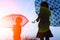 Happy Kids with an umbrella silhouette on nature in the park sunset