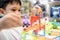 Happy kindergarten kid boy playing with rail road toy game,asian little child having fun enjoy with toys car in nursery,