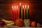 Happy Kwanzaa. Seven candles red, black and green on wooden background.