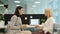 Happy ladies colleagues talking and laughing working in shared workspace