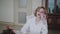 Happy lady speaking on phone at table with bouquet of roses