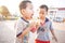 Happy Laotians twin boys enjoy eating melting ice cream cones on a hot summer day