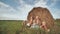 Happy large family sits near a sheaf of straw in the field.