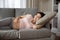 Happy late pregnant woman lying on sofa, relaxing at home