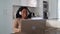 Happy Latin woman having fun doing video call using laptop at home