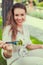 Happy latina woman holding salad with toothy smile in park selective focus