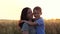 A happy laughing boy hugs his mother. The silhouette of a family at sunset. Portrait of a child and a mother. Mom and