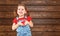 Happy laughing child girl with heart Valentine`s Day, wooden