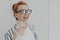 Happy laughing ginger woman standing in kitchen in morning with glass of pure mineral water