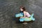 Happy laughing girl enjoying swimming in sea with rubber ring crocodile