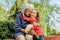 happy and laughing grandmother and her granddaughter in the park on a bench