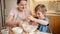 Happy laughing little boy mixing dough ingredients in big bowl. Children cooking with parents, little chef, family