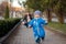 Happy laughing little boy playing with father in the park, running away from him. Active family leisure