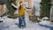 Happy laughing millennial couple having fun on snowy backyard dancing spinning hugging. Wide shot portrait of cheerful