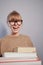 Happy laughing nerd student girl holding stack of books