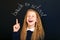 Happy laughing school child near school blackboard.