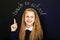 Happy laughing school child near school blackboard