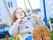 Happy laughing teen girl with long hair wearing a knitted cardigan enjoying a swing ride on a sunny autumn playground in