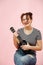 Happy laughing woman with black ukulele over pink background