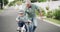 Happy, learning bike and a grandfather and child in the street for bonding, playing and childhood. Smile, family and an