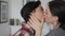 Happy lesbian couple in love hugging kissing passionately standing at home.